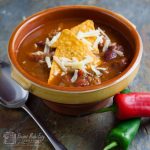 bowl of spciy mexica soup with chilli and spoon by side