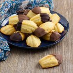 Madeleines on a serving plate with one on work top