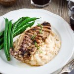 serving of marinated lamb with haricot bean mash with green beans on the side.