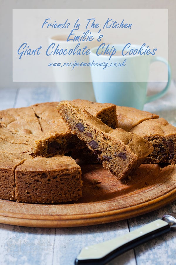 Giant chcolate chip cookie on wooden board cut into wedges