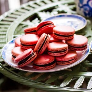 Macarons on a serving plate on green garden table.