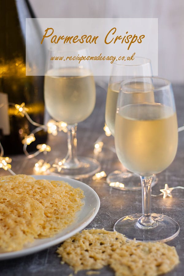 Parmseasn crips on plate with glasses in background