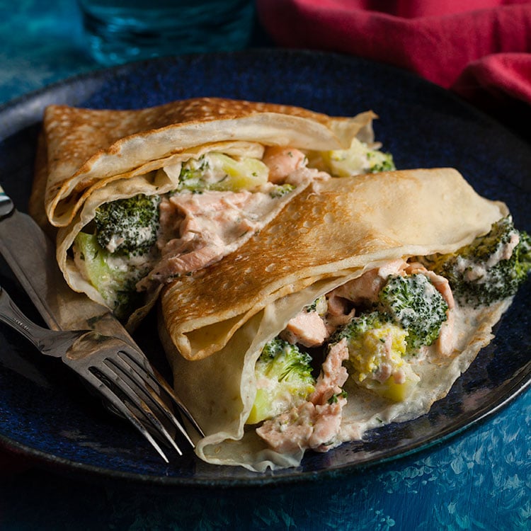 two savoury pancakes with salmon and broccoli on a plate
