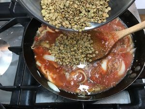 adding lentils to pan