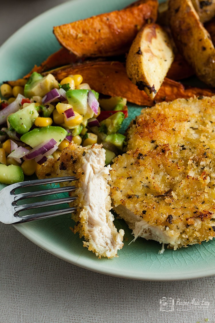 serving of oven baked chicken schnitzel with piece on fork.