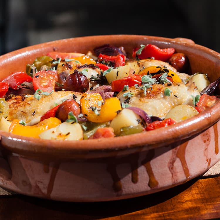 Spanish chicken with chorizo, peppers and olives in a casserole dish.