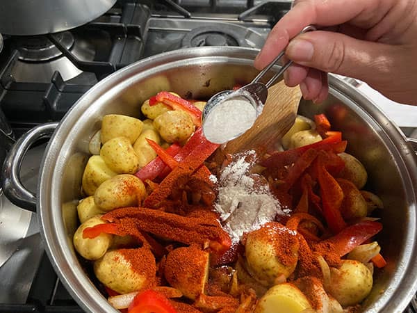 adding flour to vegetable in the pan.