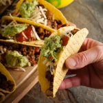 hand taking a spicy beef taco.