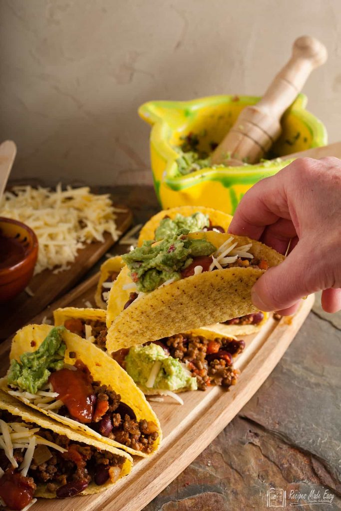 handing taking a spicy beef taco.