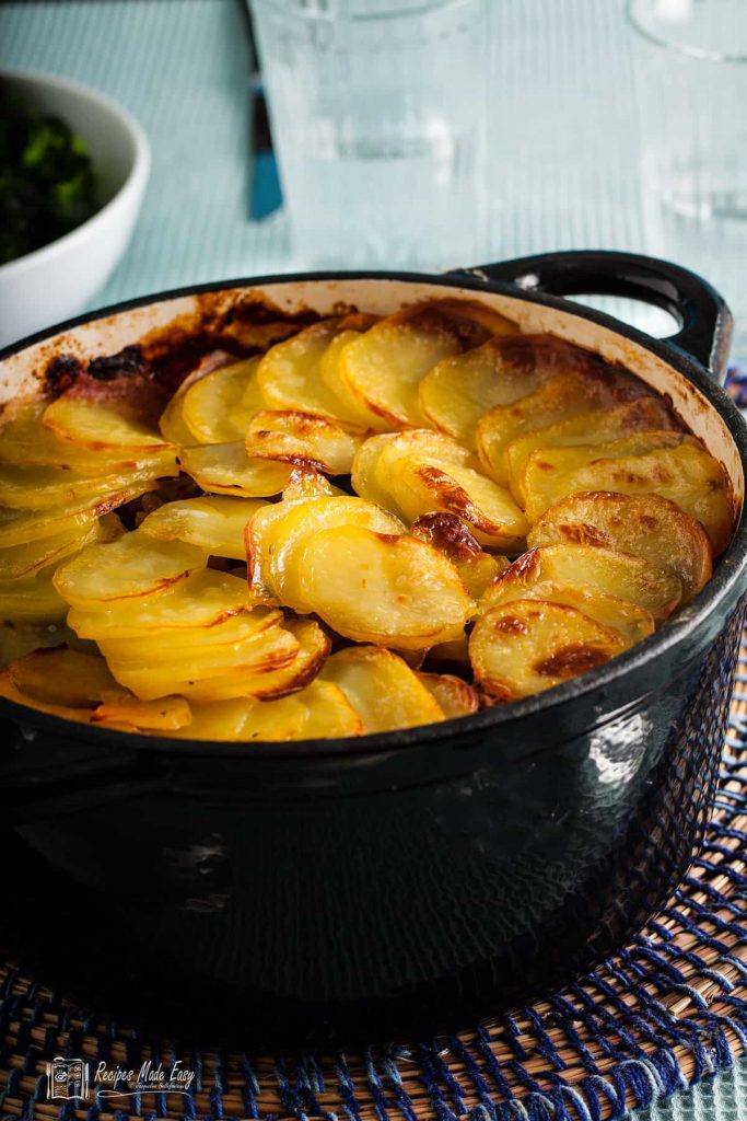 beany lamb hotpot ina black casserole dish on table.