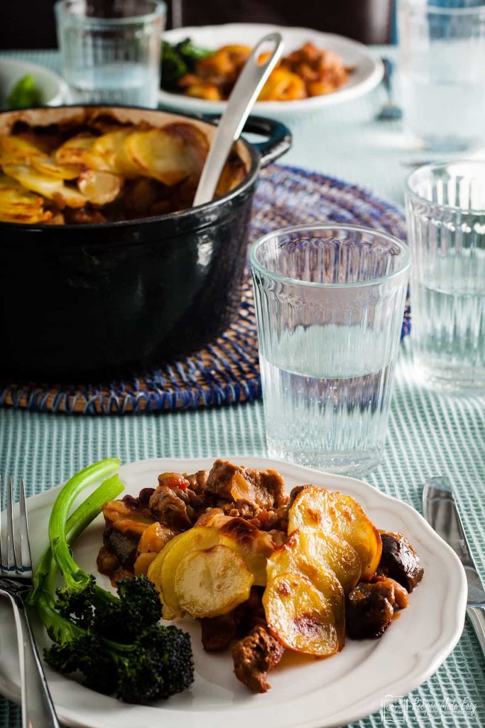 serving of beany lamb hot pot on a plate with fresh broccoli.