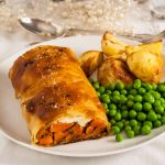 serving of roasted spiced carrot and feta strudel on a plate with veg.