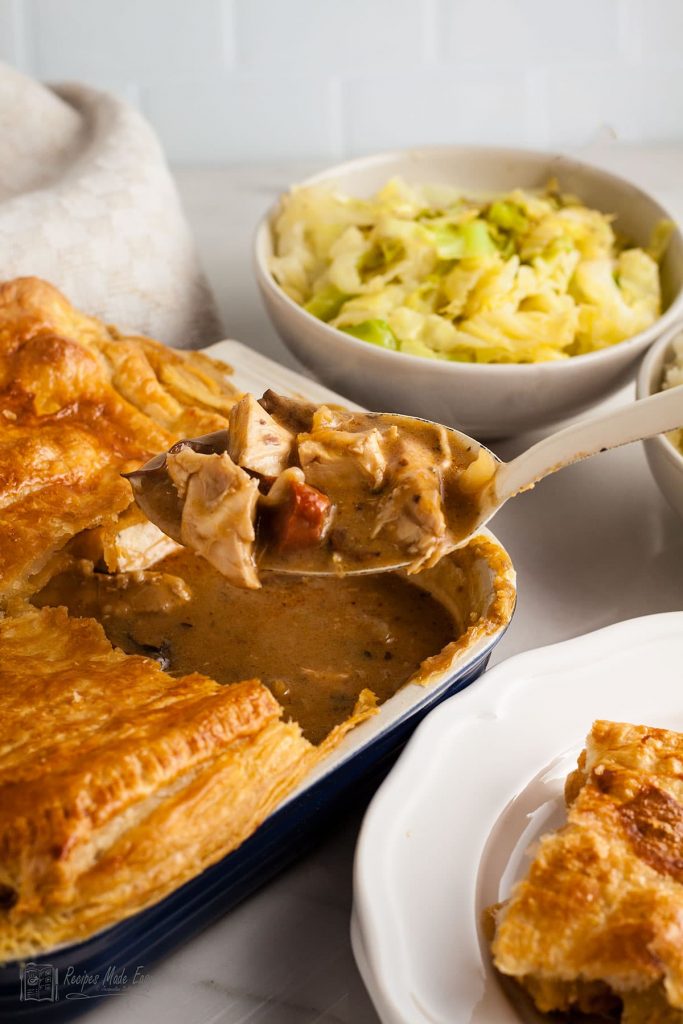turkey and chorizo pot pie in a dish with filling on a serving spoon.