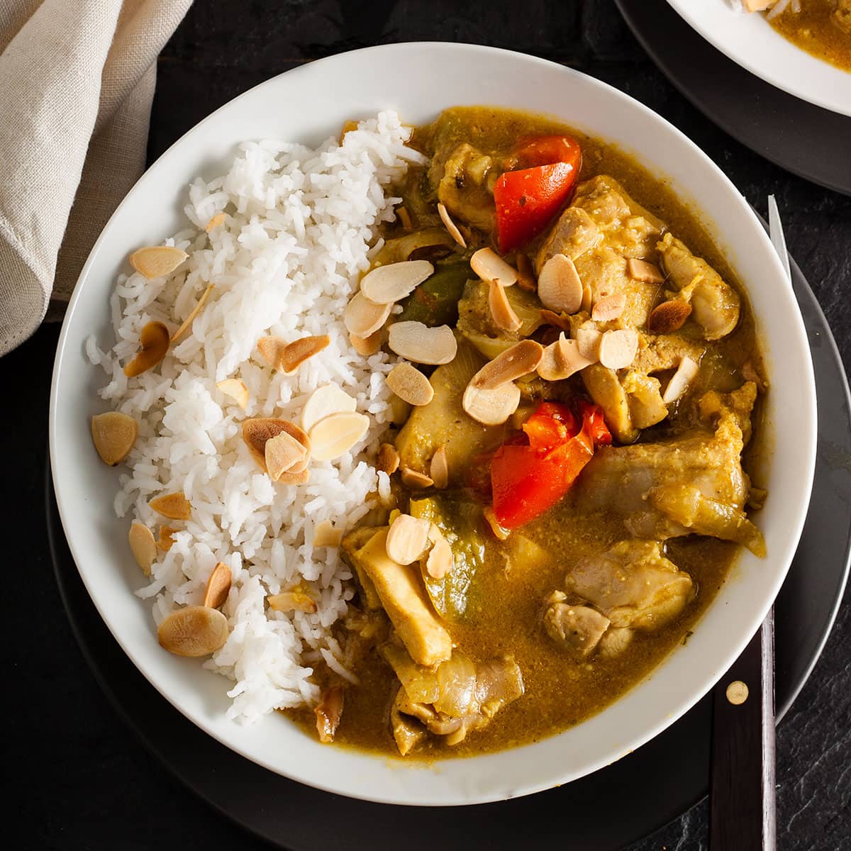 easy chciken curry servd with rice and a sprinkling of flaked almonds.