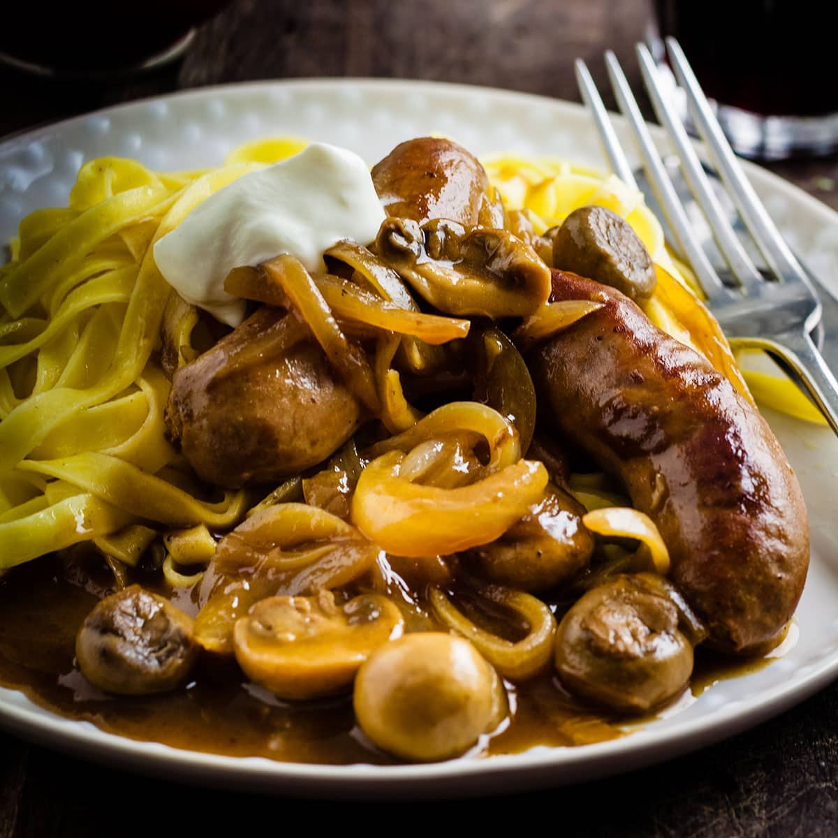 plate of sausage stroganoff served with noodles.