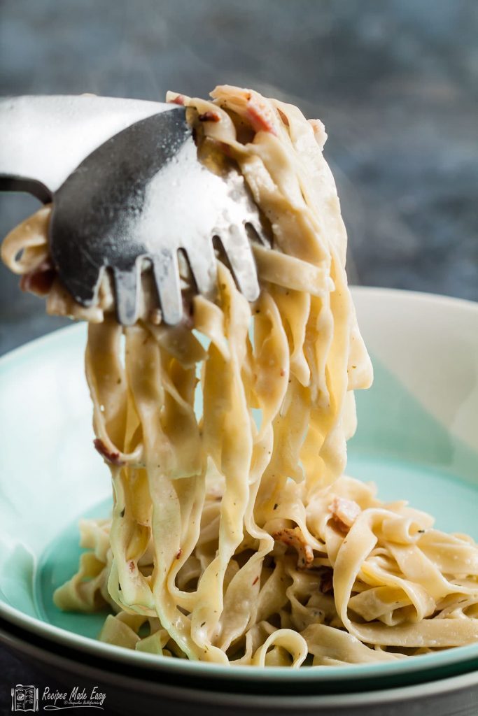 Serveing pasta with tongs into a bowl.