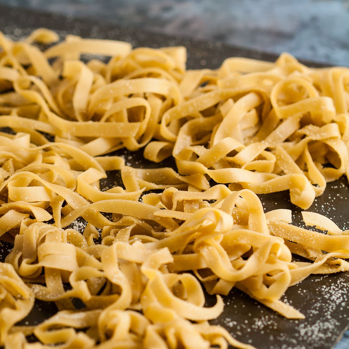 homemade tagliatelle pasta on a tray.