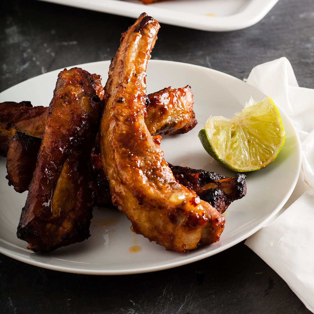 plate of red hot ribs with squeezed wedge of lime
