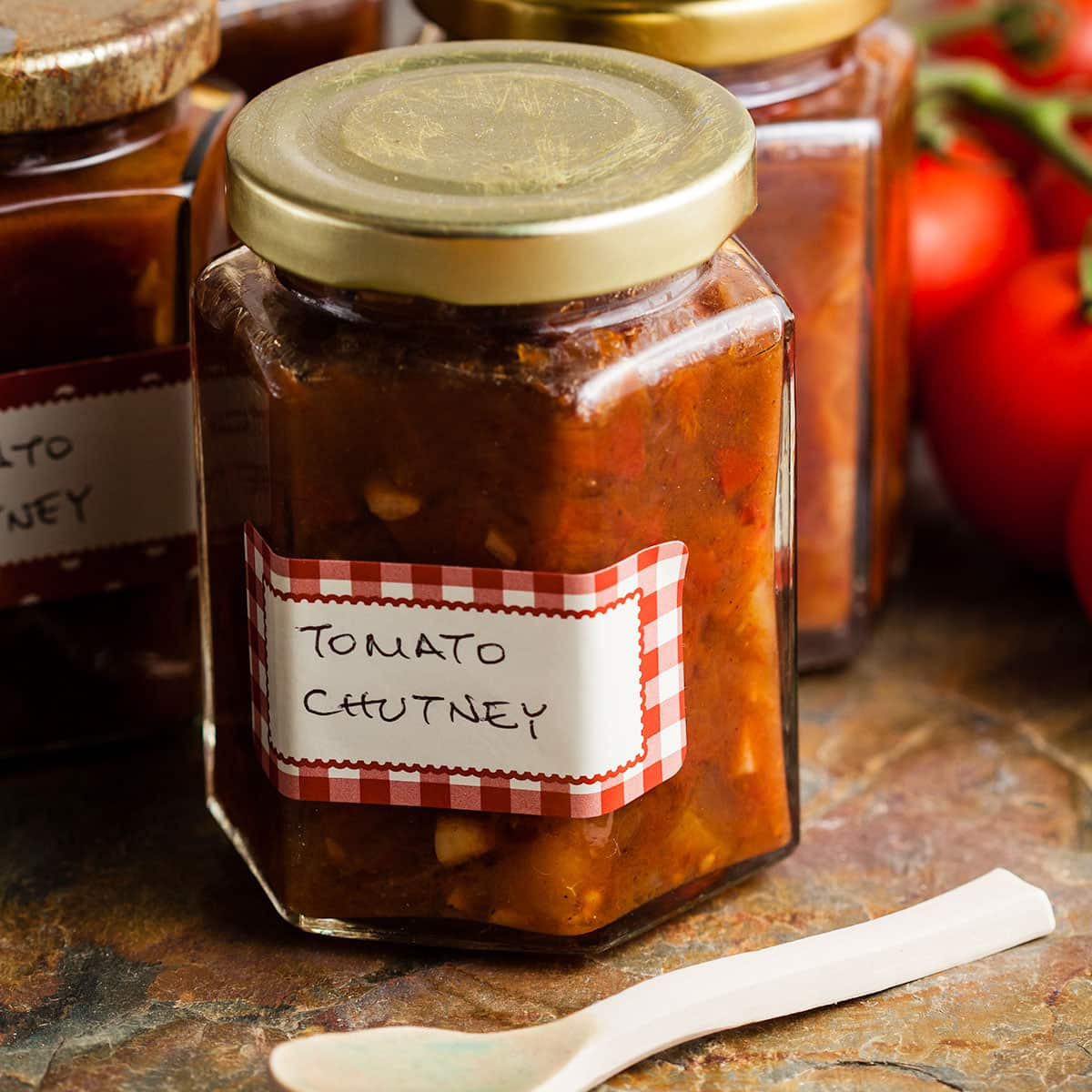 jars of easy tomato chutney with ceramic spoon in front.