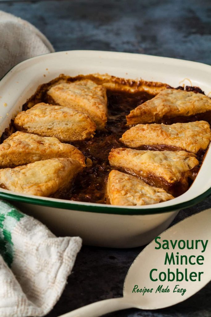 savoury mince cobbler in baking dish with recipe name overlaid on serving spoon.