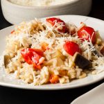 plate of mediterranean vegetable risotto sprinkled with cheese.