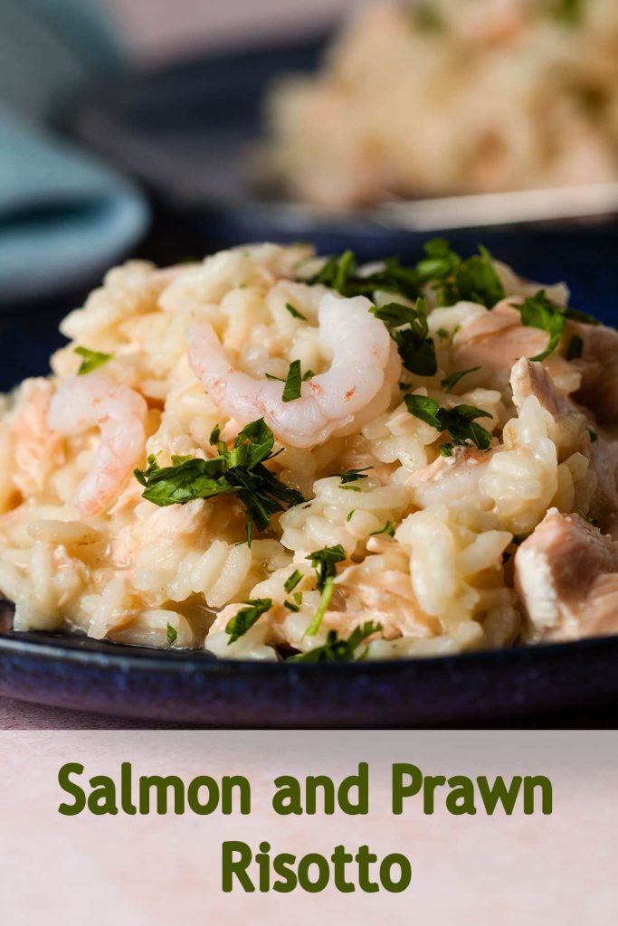 salmon and prawn risotto garnished with chopped parsley.