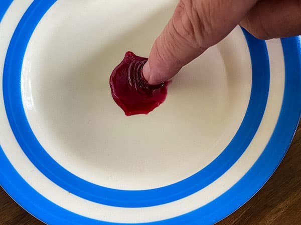 Finger in cooled jam for wrinkle test.