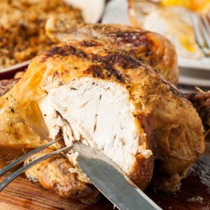 roast chicken part carved with carving knife and fork.