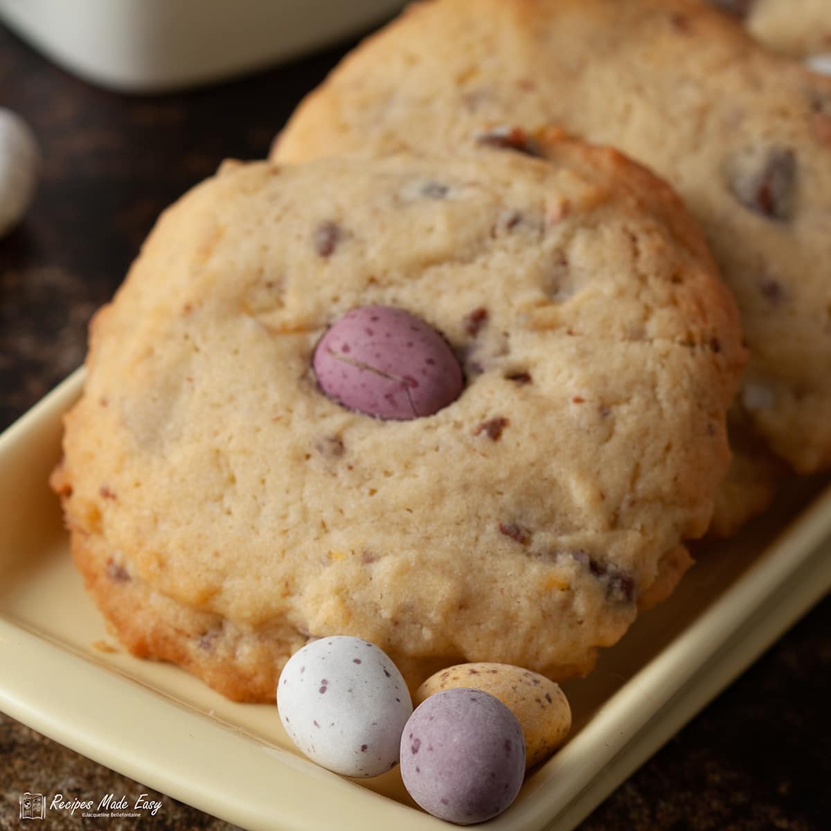 2 chocolate mini egg cookies on a plate with extra mini eggs.