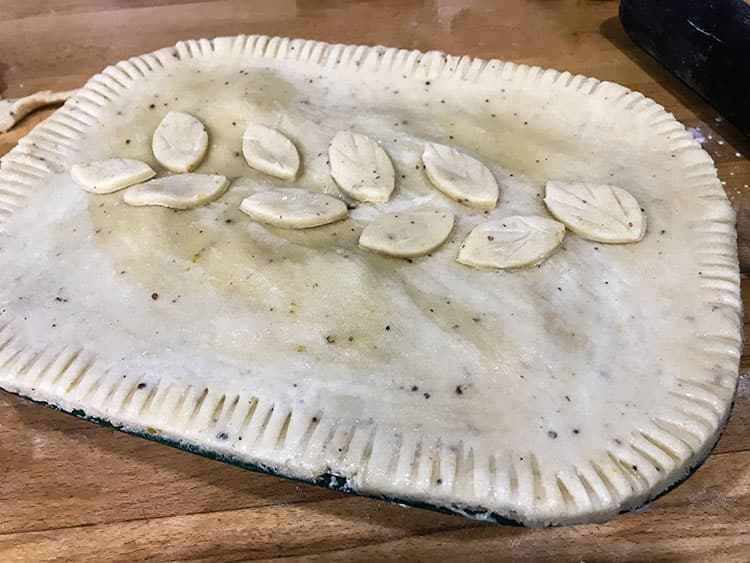 uncooked steak and red wine pie decorated with pastry leaves.