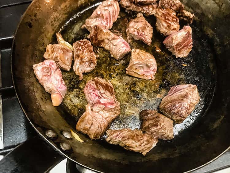 browned meat in frying pan.