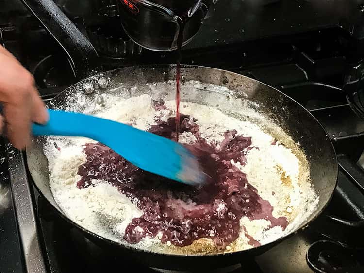 adding wine to flour in pan.
