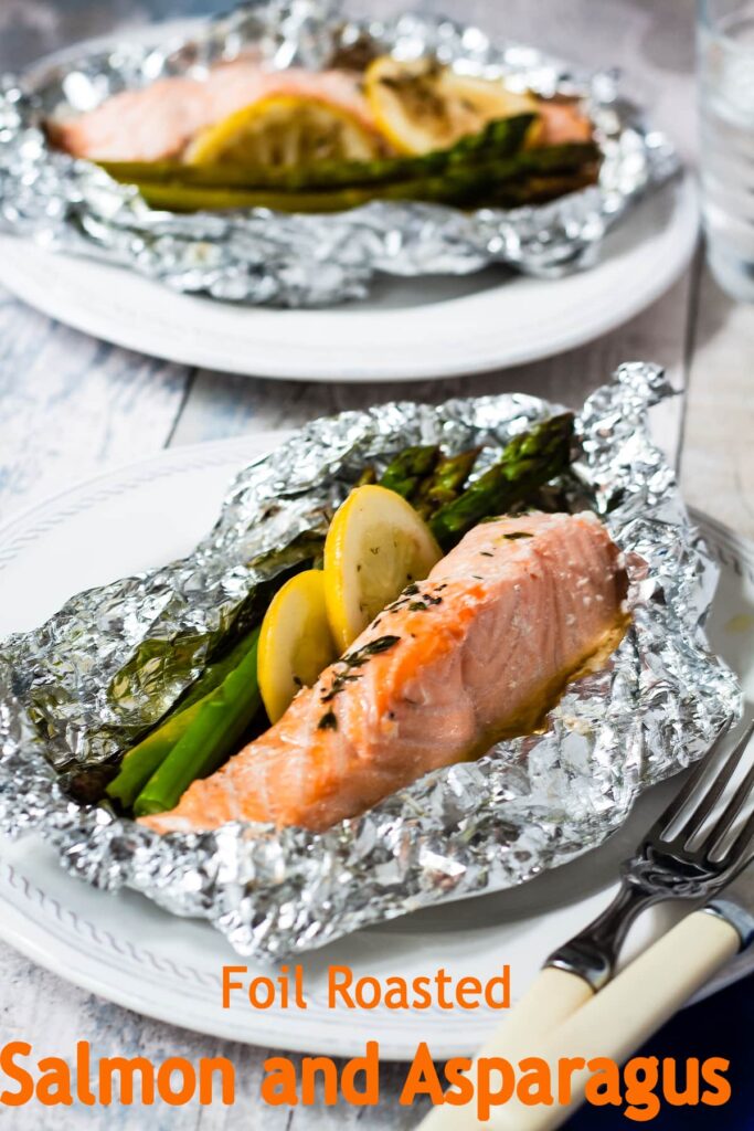 two servings of foiled baked salmon and asparagus