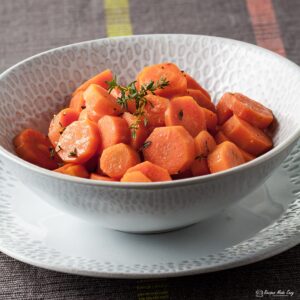 bowl of lemon and thyme glazed carrots on a plate.